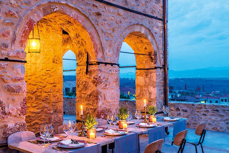 Diner privé healthy au Manoir Leoncini : un éclairage subtil aux bougies, une table de style monastère joliment dressée et un service personnalisé.
